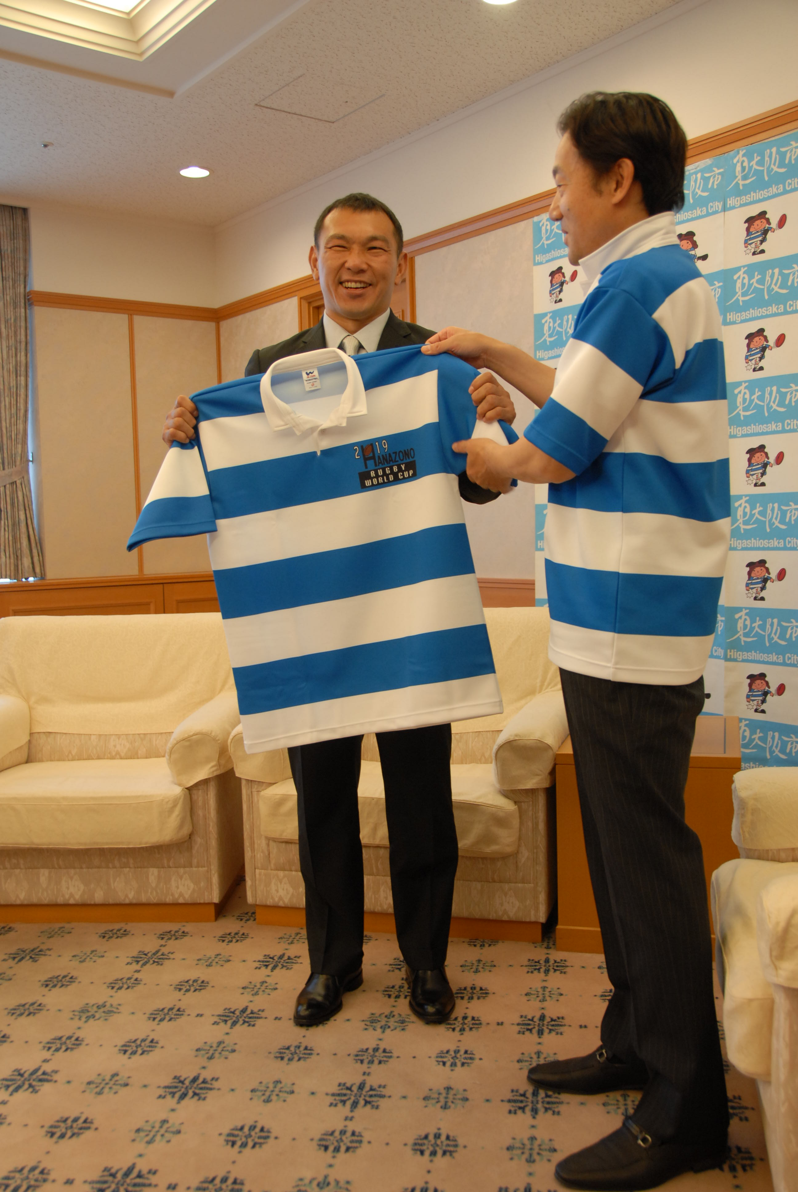 市長が元木由記雄さんにラガーシャツを渡している様子