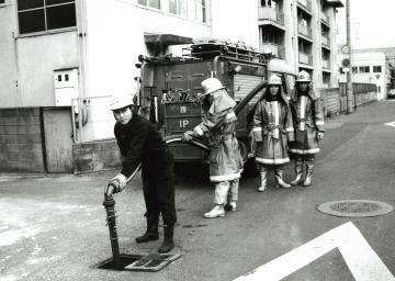 西消防署の職員とポンプ車の写真