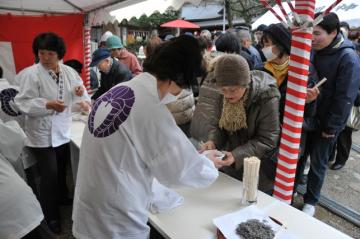 粥占神事で参拝者に小豆粥がふるまわれている写真