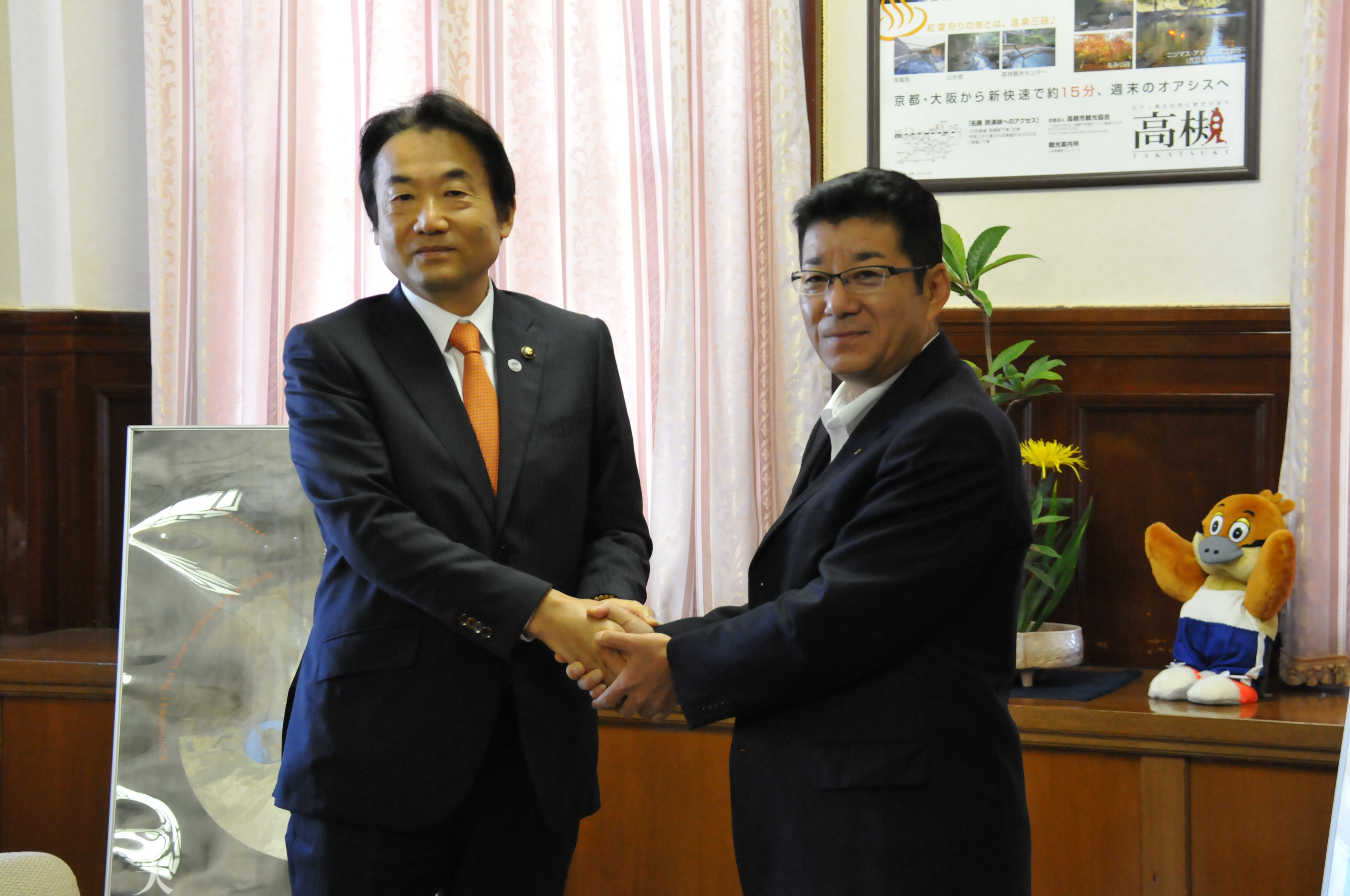握手を交わす　左：野田市長　右：松井知事
