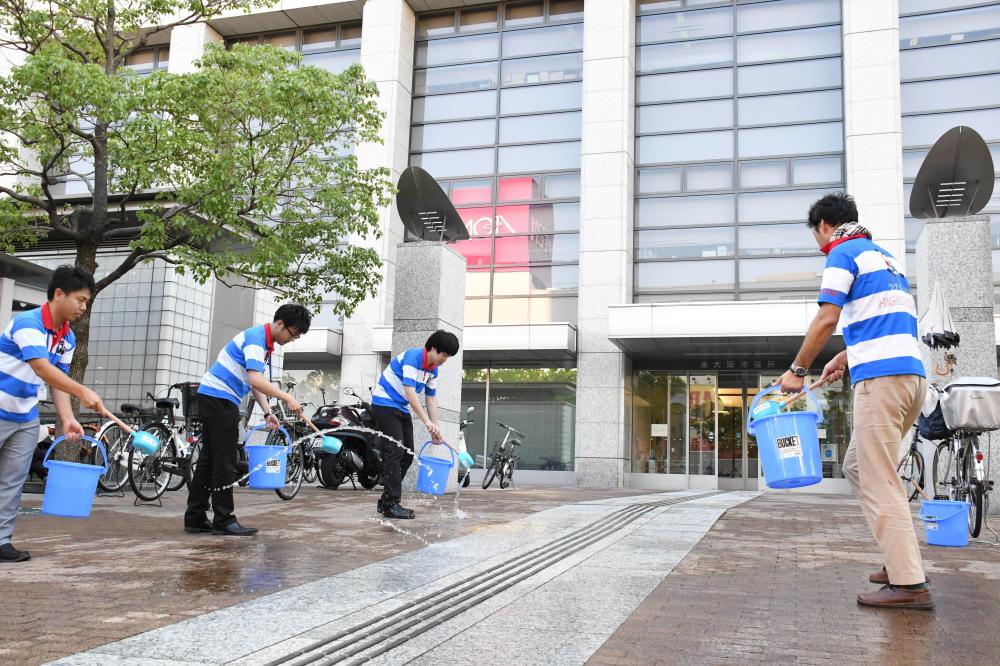 打ち水を行う職員ら