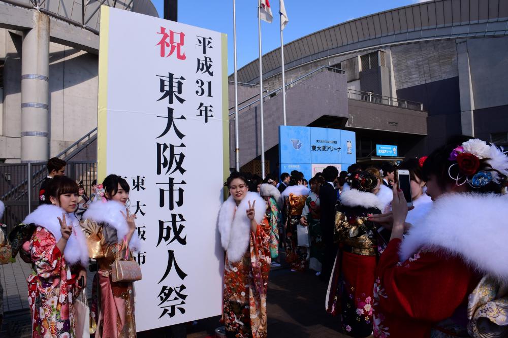 看板で記念写真を撮る新成人