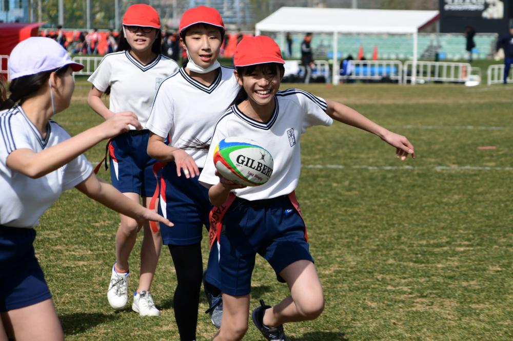 タグラグビーをプレーする小学生