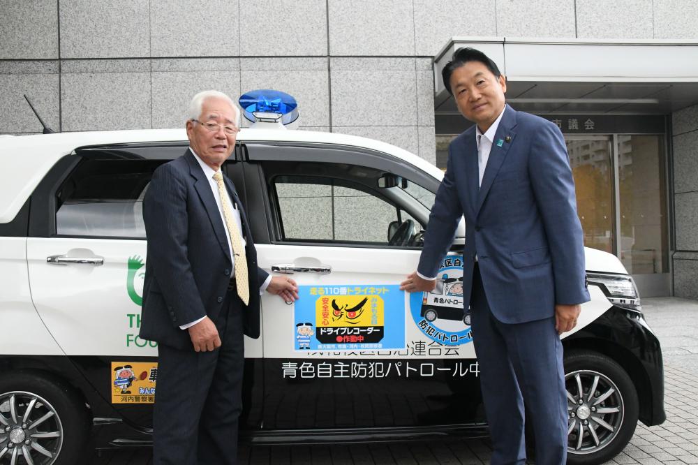 ステッカーを張り付けた車と市長