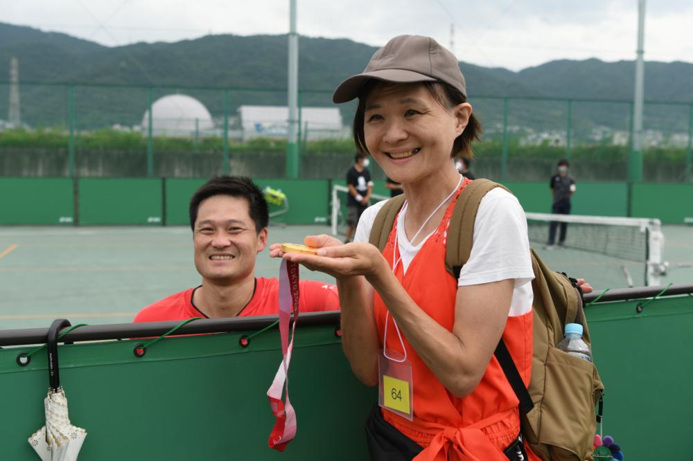 金メダルを持ち、国枝選手と記念写真を撮る参加者