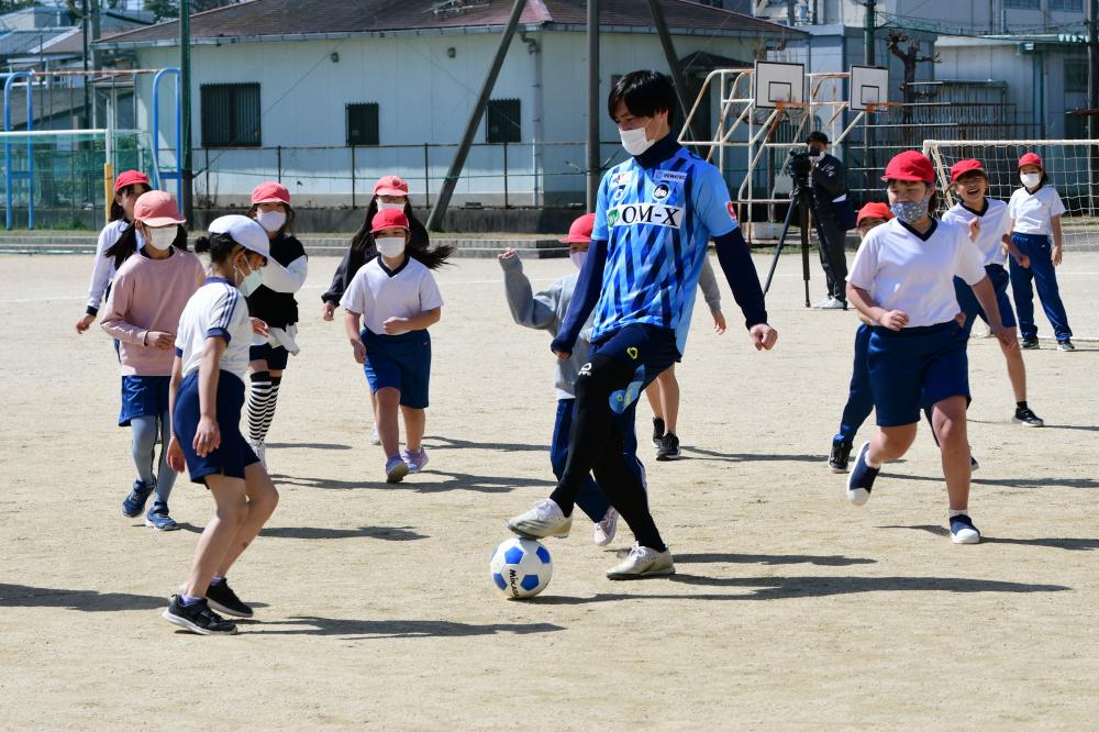 児童とサッカーをする武田選手