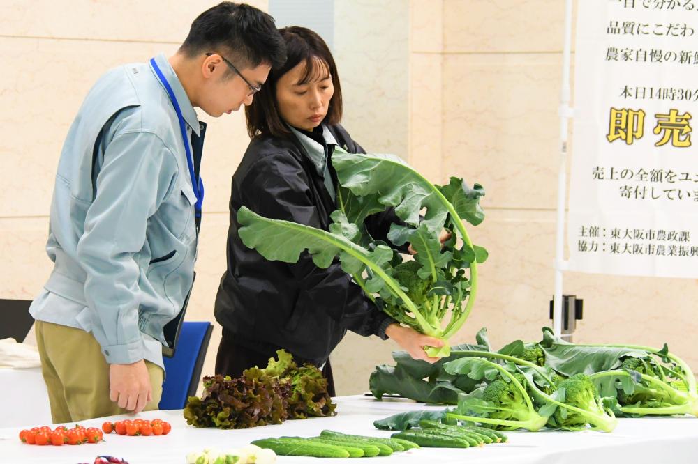 審査員が野菜を手に取り審査している様子