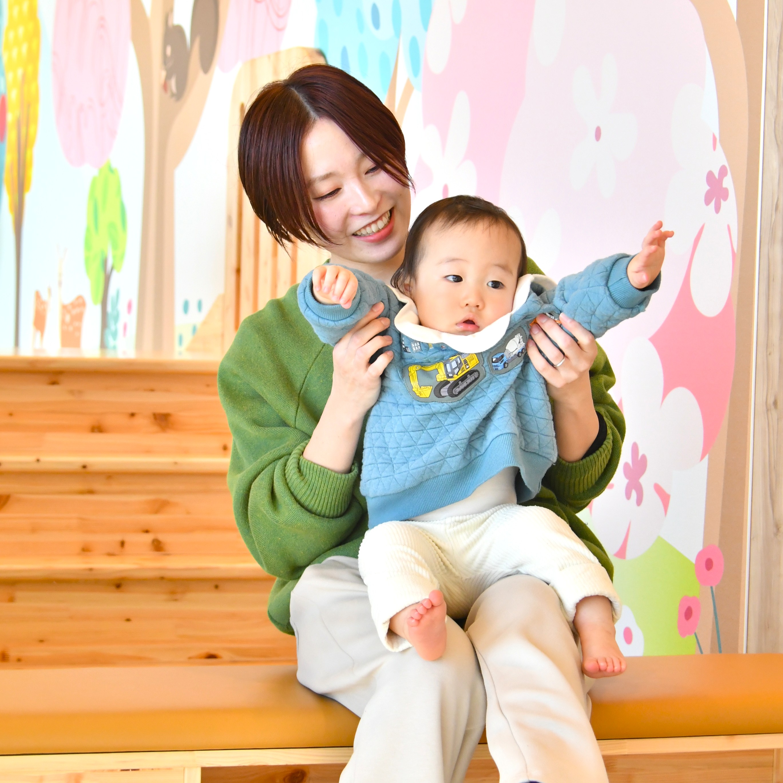 子どもを膝に乗せる母親